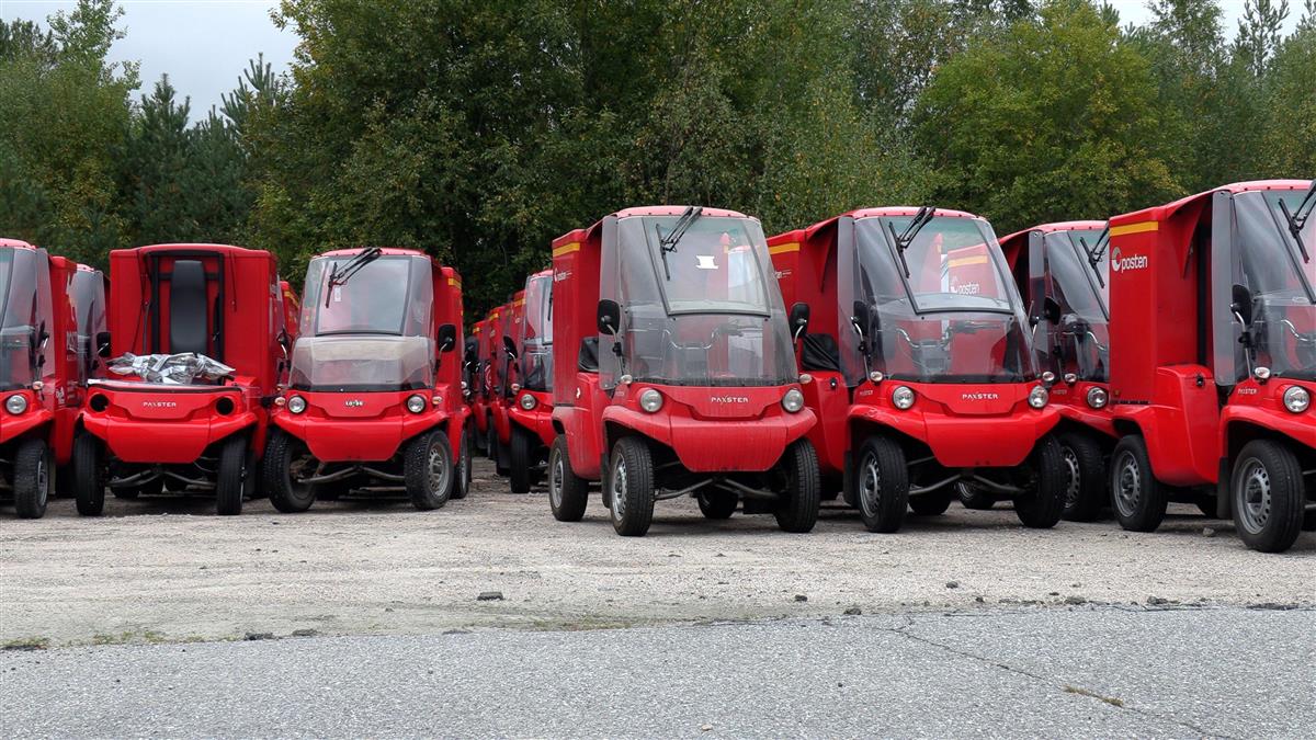 Rekke med små røde elektriske postbiler - Klikk for stort bilde
