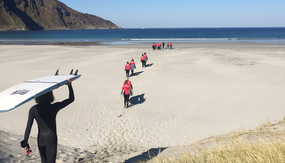 Elever bærer surfebrett ned til stranda i Hoddevika. - Klikk for stort bilde