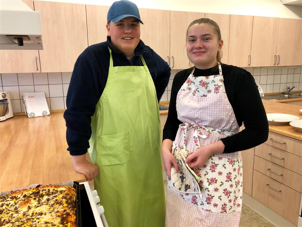 Gutt og jente som lager pizza på skolekjøkkenet - Klikk for stort bilde