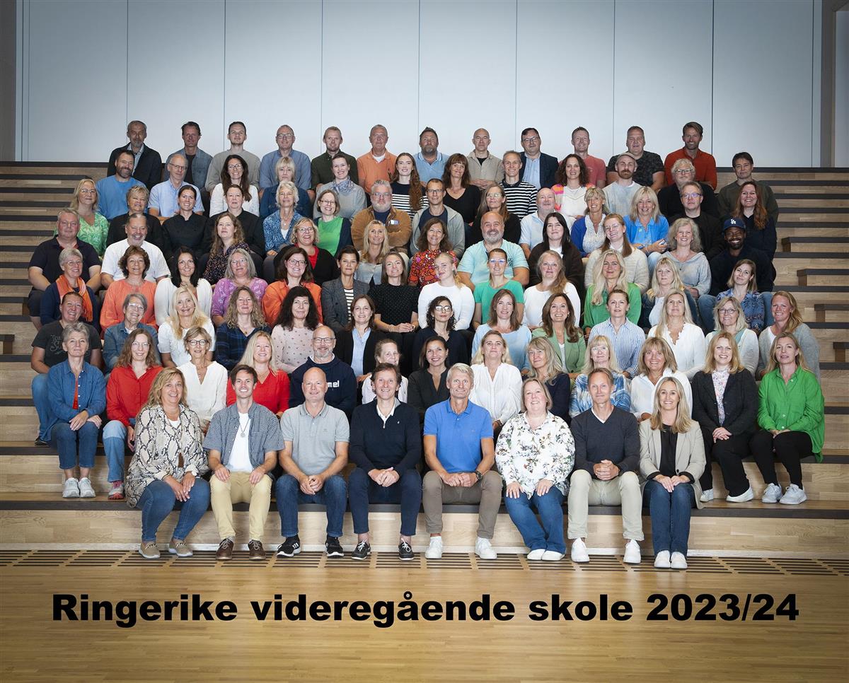 Gruppebilde med teksten 'Ringerike videregående skole 2023-24' hvor alle ansatte på skolen sitter i et amfi. - Klikk for stort bilde