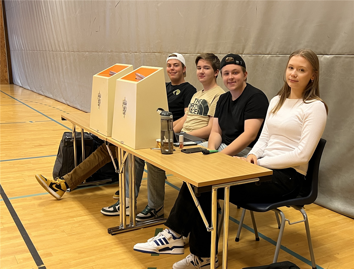 Fire elever bak bord med stemmeurner foran seg.  - Klikk for stort bilde