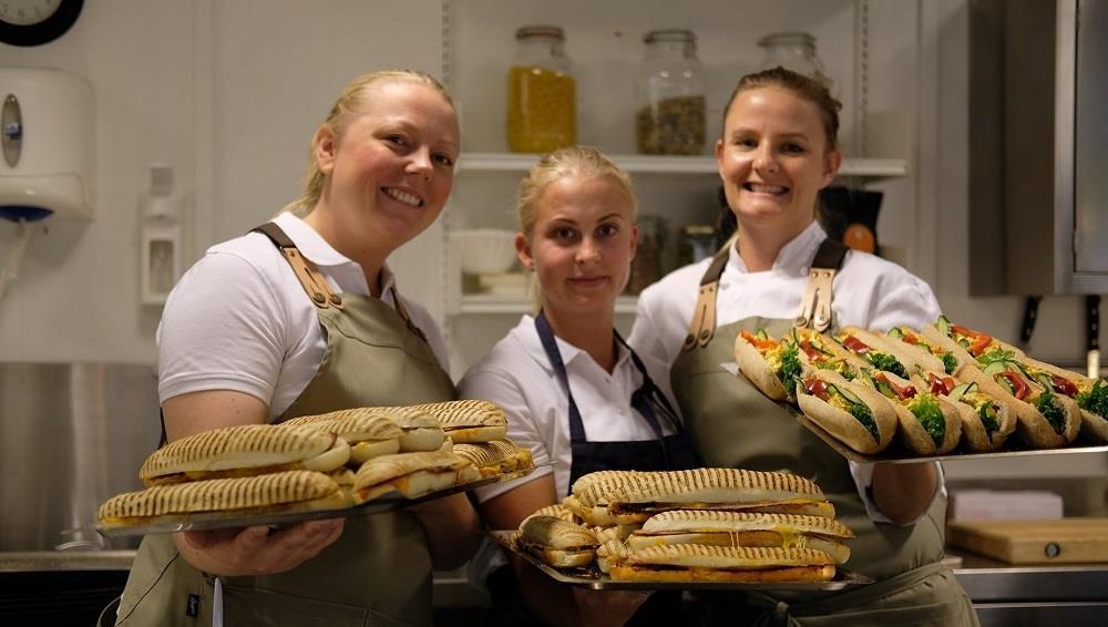 Tre blide damer som holder fat med baguetter og panini - Klikk for stort bilde