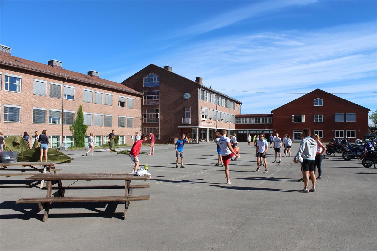 Skolegården på Asker videregående. Elever er ute i solen.  - Klikk for stort bilde