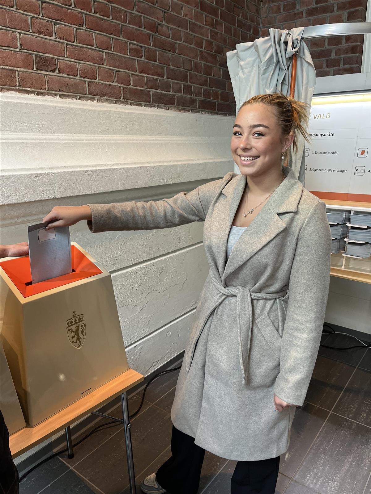 En elev putter stemmeseddelen i valgurnen under skolevalget - Klikk for stort bilde