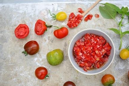 Skål med tomatsalsa, og hele og halve tomater på en benk. - Klikk for stort bilde