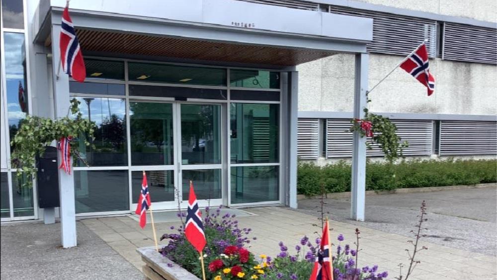 Skolens hovedinngang, dekorert med norske flagg - Klikk for stort bilde