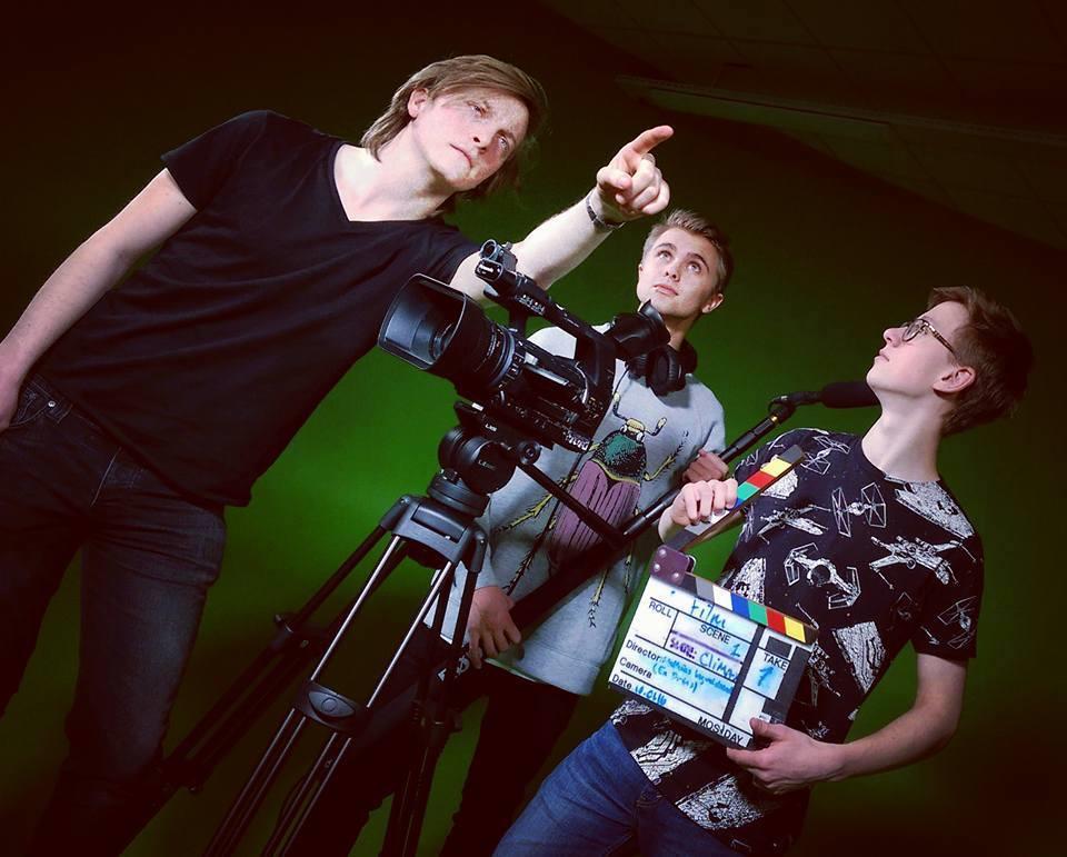 Matias, Mike og Tobias i greenscreen studio. Tre elever foran en grønn vegg med kamera og mikrofon - Klikk for stort bilde