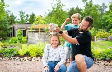 Bilde fra Stine Sofies Stiftelse, voksen mannsperson sammen med to barn i hage - Klikk for stort bilde