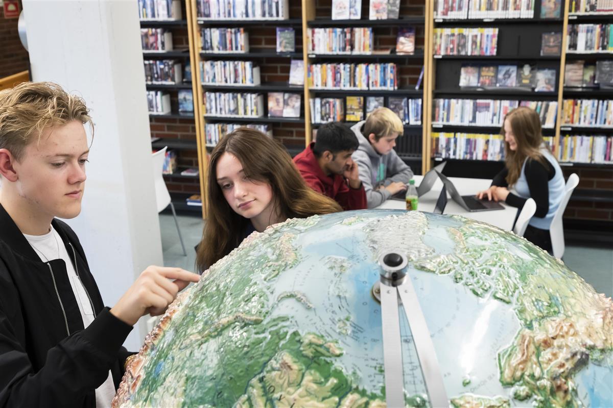 Elever studerer globusen - Klikk for stort bilde