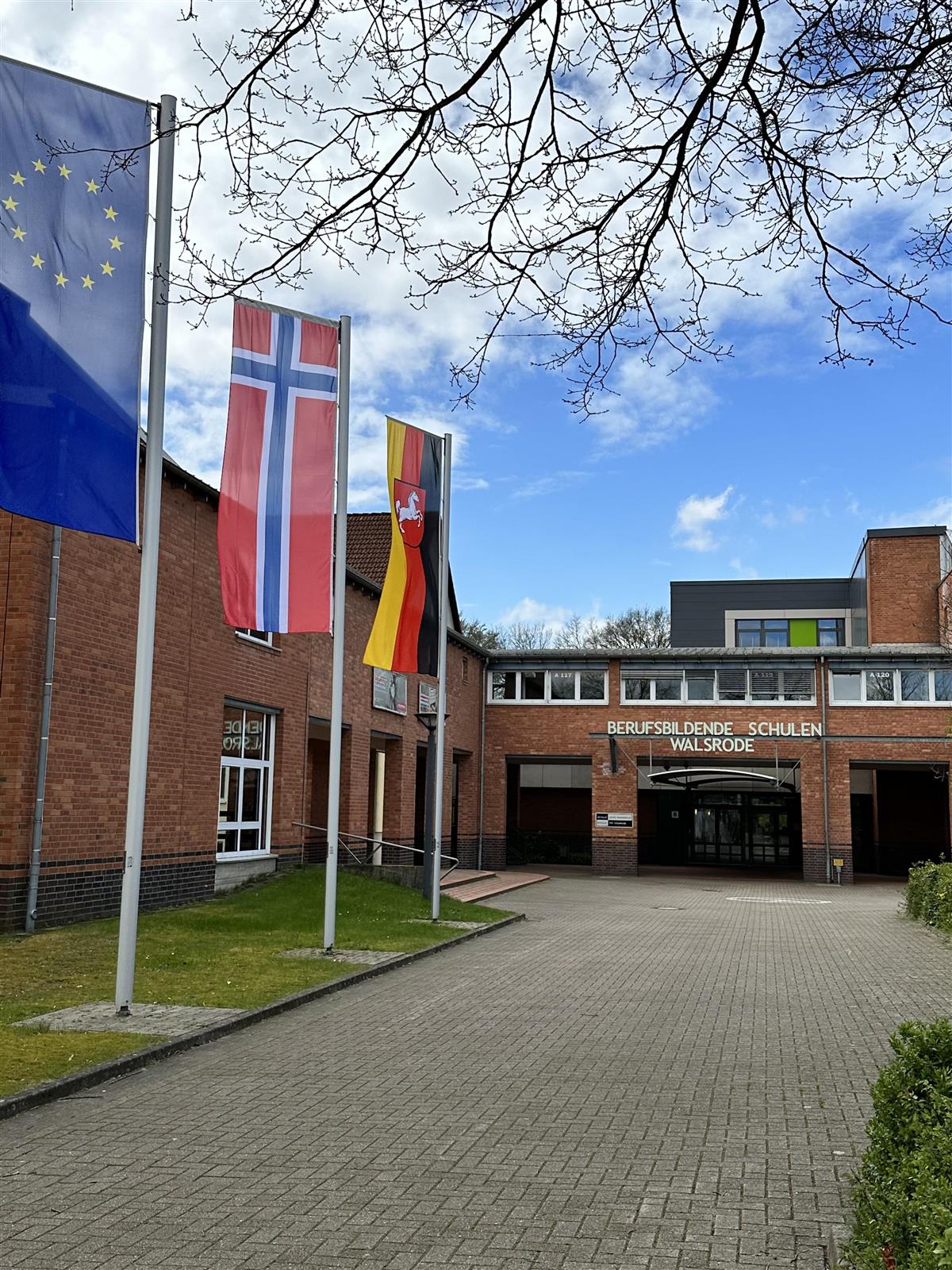 Det europeiske flagget, det norske flagget og det tyske flagget vaier utenfor skolen BBS Walsrode. - Klikk for stort bilde