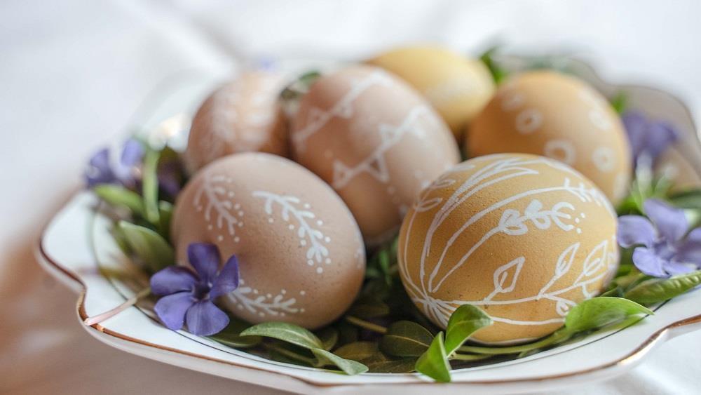 Brune egg malt med hvit farge på et lite fat med blomster - Klikk for stort bilde