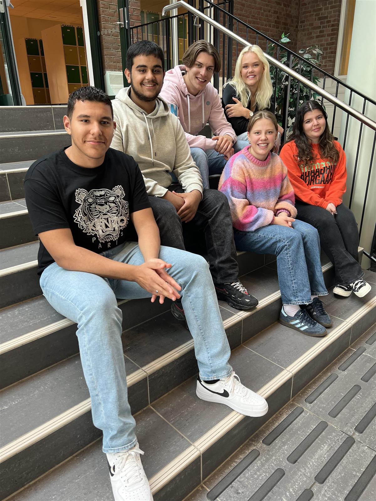 En gruppe ungdommer sitter i en trapp - Klikk for stort bilde